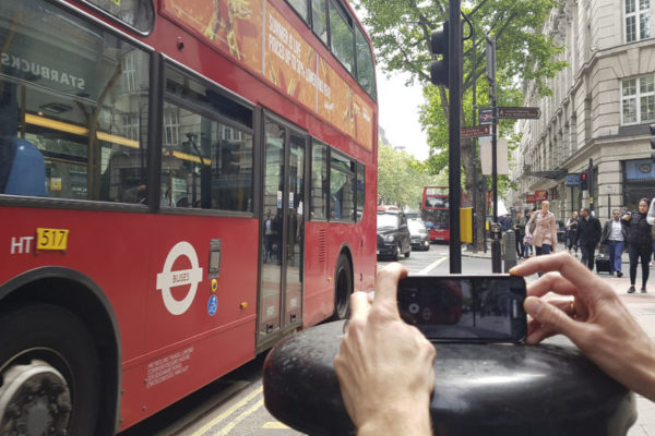 smartphone filmmaking course. A person films a London bus using a mobile phone