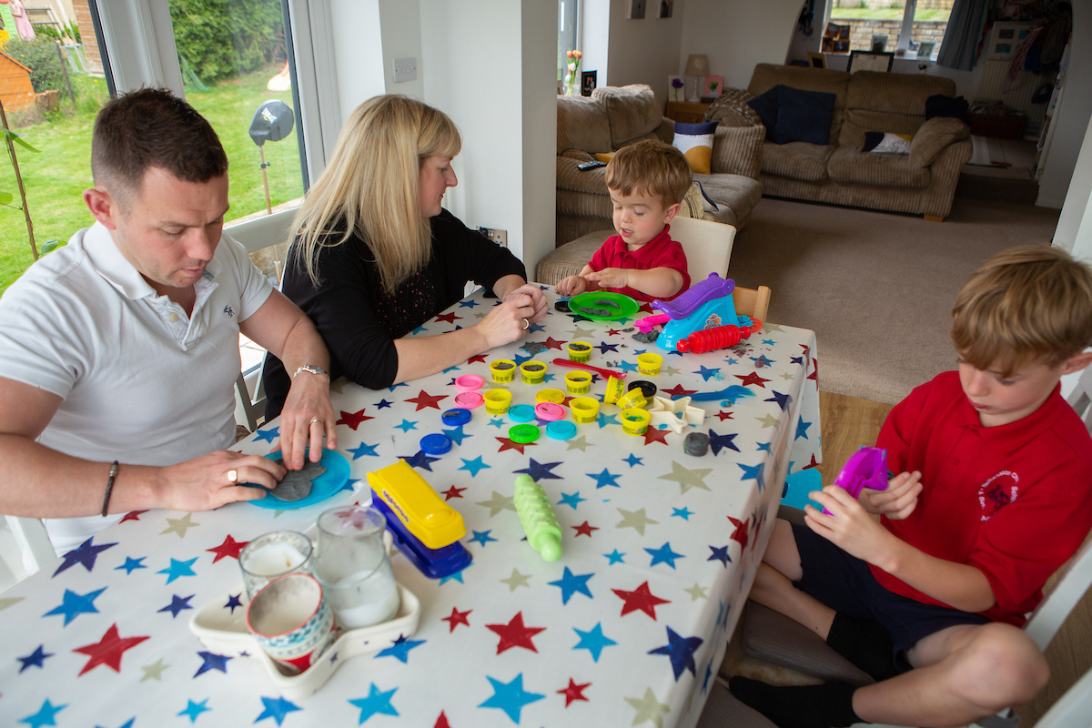 a young carer playing with play doh around the kitchen table